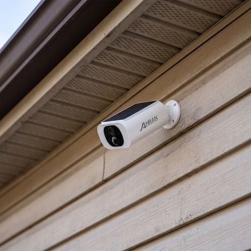 Solar security camera mounted under the eaves of a house