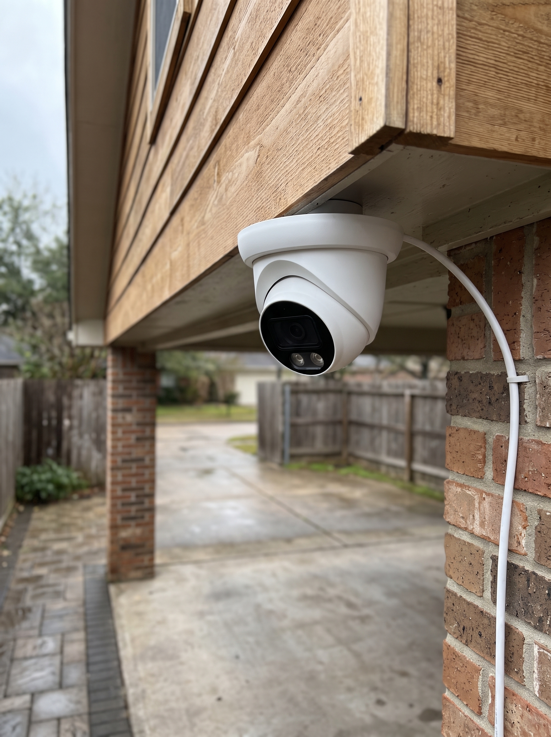 PoE dome camera under a timber soffit with a single cable run to the wall