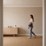 The camera turned to follow a woman walking across a living room