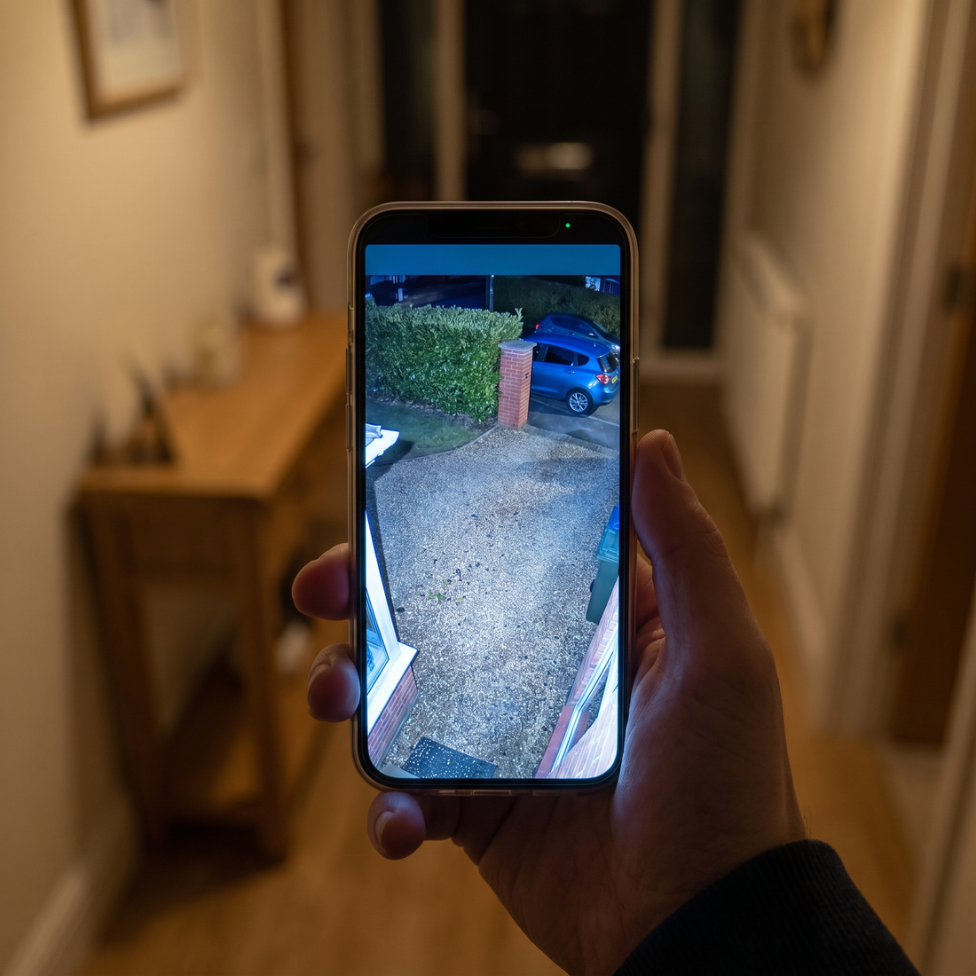 A phone showing the camera's full colour night view of a driveway