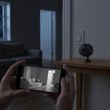 A phone showing the camera's black and white night view of a dark room